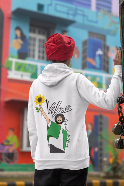 Back view of a female model wearing a comfortable white hoodie featuring the phrase "Vibe Teri Meri" in a modern font on a portrait of Diljit Singh holding up a sunflower, perfect for expressing your unique style and feeling the rhythm.