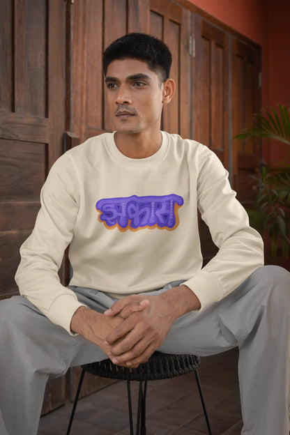 First front view of a male model wearing an cream sweatshirt featuring "Jhakas" in a stylish font.