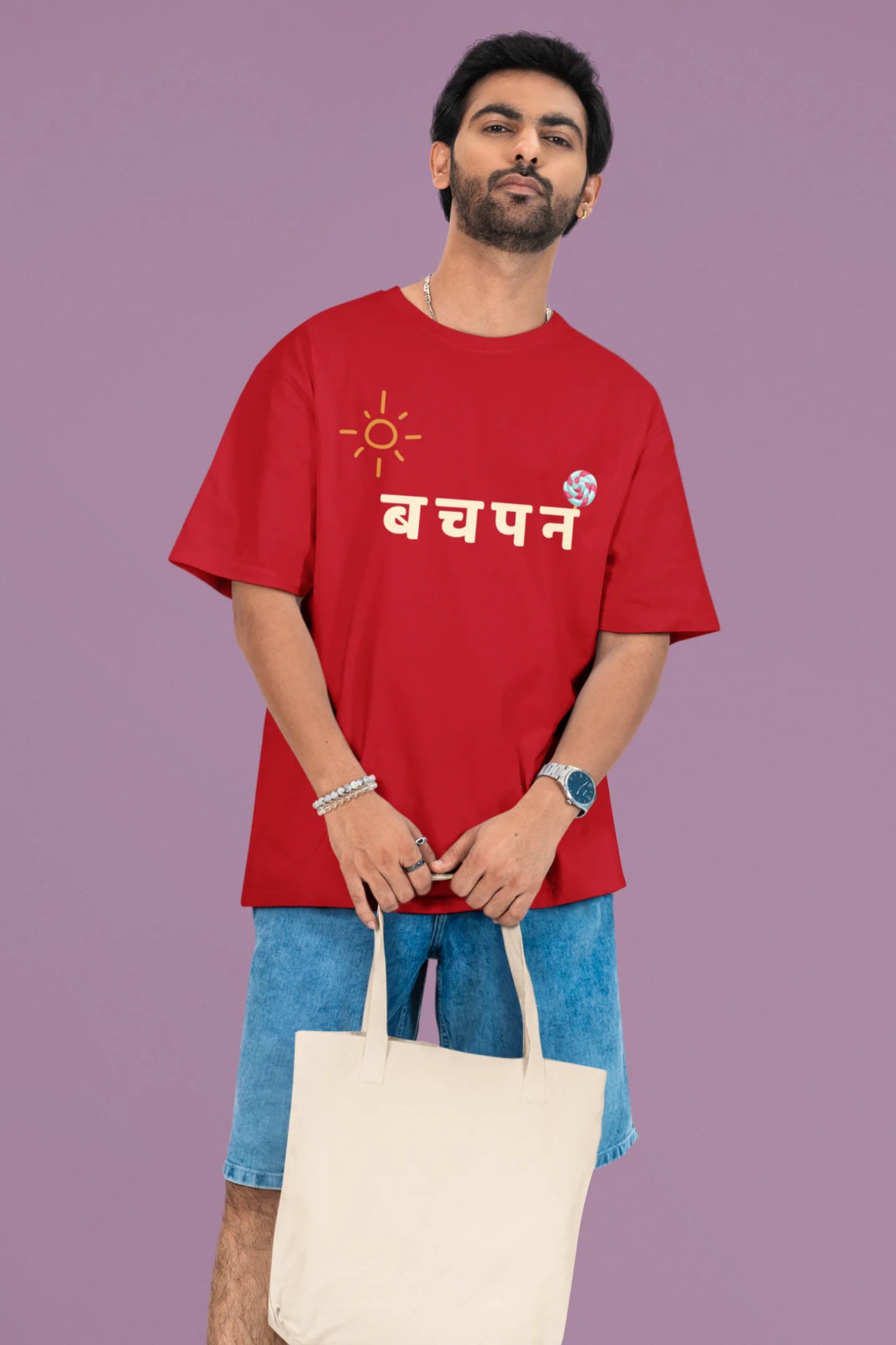 2nd front view of a male model wearing a red oversized t-shirt with a design representing "Bachpan" (childhood) and the concept of "Khatta Mitha" (sweet and sour).