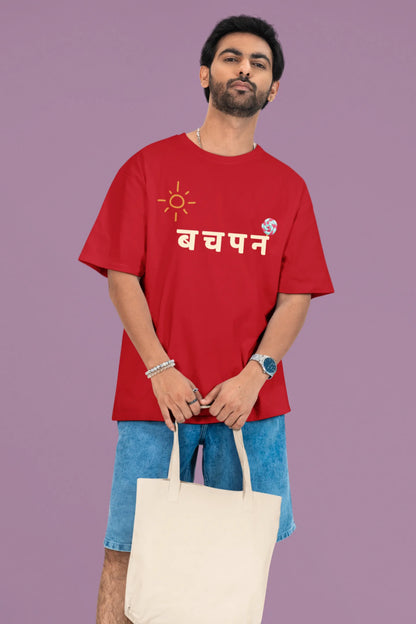 2nd front view of a male model wearing a red oversized t-shirt with a design representing "Bachpan" (childhood) and the concept of "Khatta Mitha" (sweet and sour).