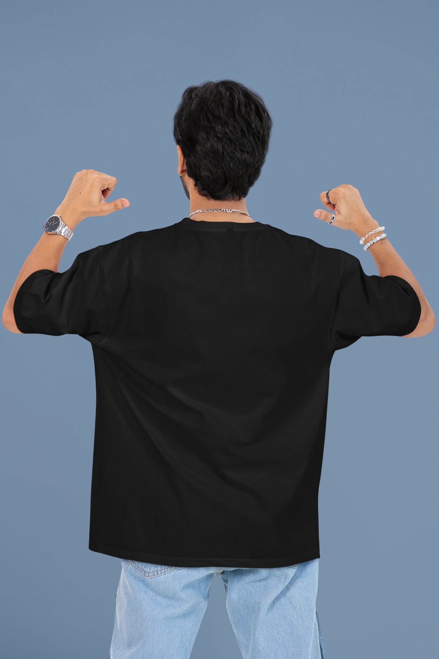 Back view of a male model wearing a black oversized t-shirt with the text "Oh Snap!" and a broken heart symbol underneath.