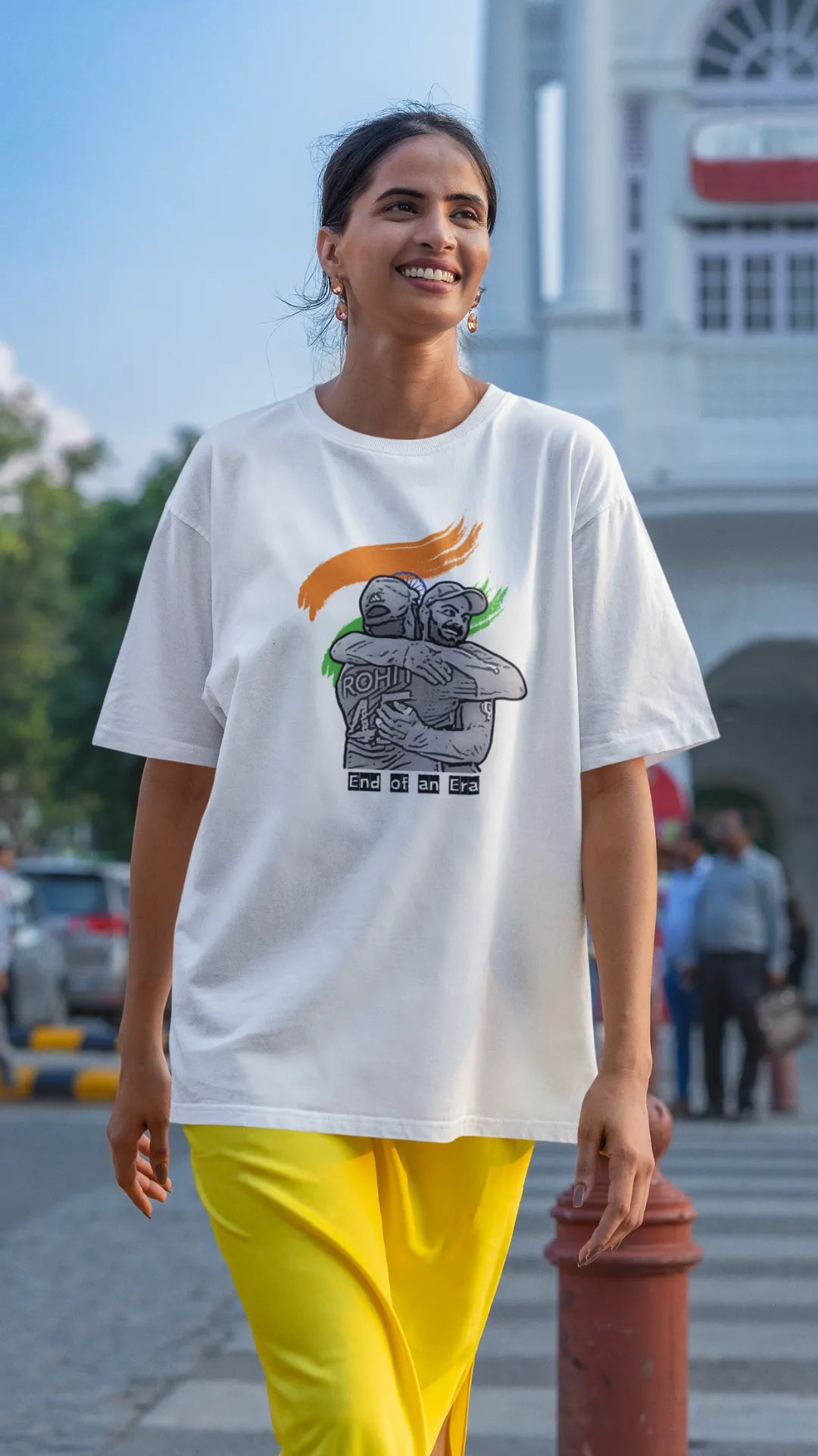 Second front view of a female model wearing an off-white oversized t-shirt featuring a photo of Virat Kohli and Rohit Sharma in a celebratory hug after the World Cup 2024 final. Ideal for Indian cricket fans who want to honor the team's victory and potentially a changing of the guard.