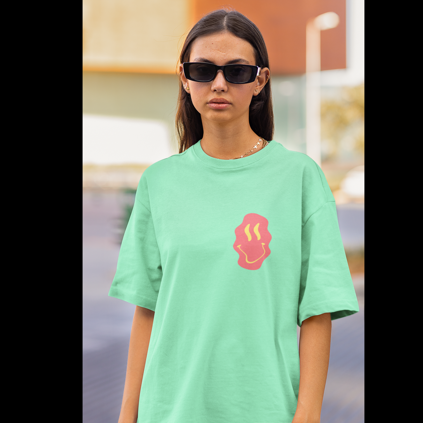 Front view of a female model wearing a mint green oversized t-shirt featuring a fun "Space Wreck" design with elements of spaceships, UFOs, and a hint of extraterrestrial life.