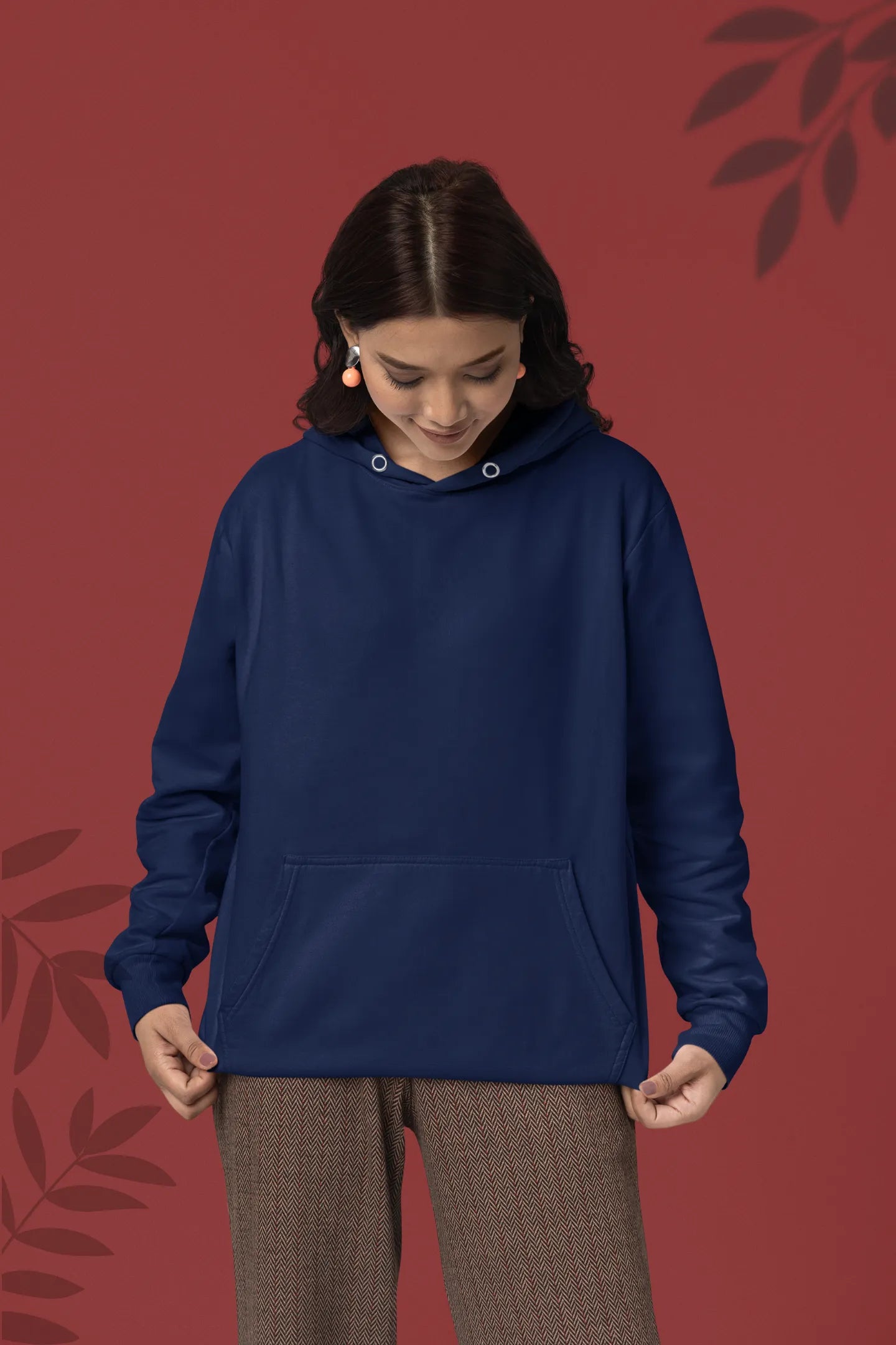 First front view of a female model wearing a navy blue hoodie with a design of a wildcat sitting on ocean waves.