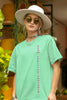 Front view of a female model wearing an mint green oversized t-shirt featuring a thought-provoking design of a man's bust with the text 