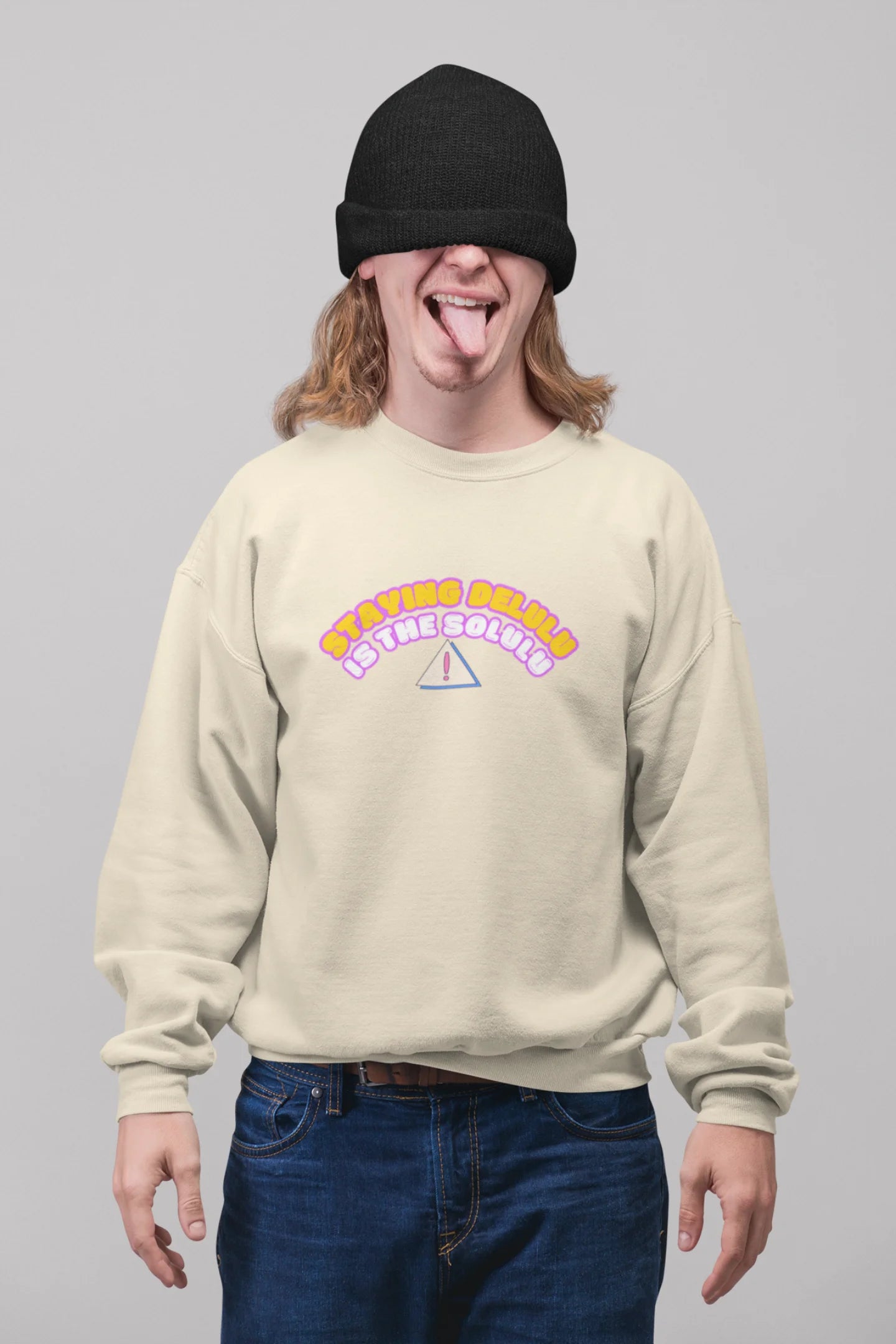 First front view of male model wearing a cream sweatshirt with the hilarious message "Stay Delulu" in a bold design. Ideal for those who love trendy slang and lighthearted humor.