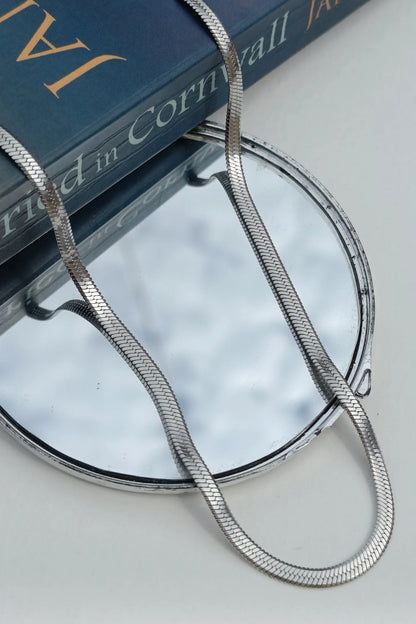 Third image of an anti tarnish silver chain necklace featuring a snake like design.