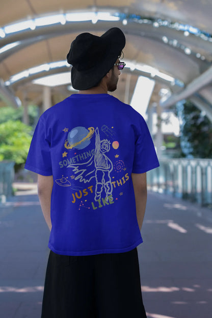 Back view of a male model wearing an royal blue oversized t-shirt with a design inspired by the "Something Just Like This" music video, featuring the word "Superheroes".