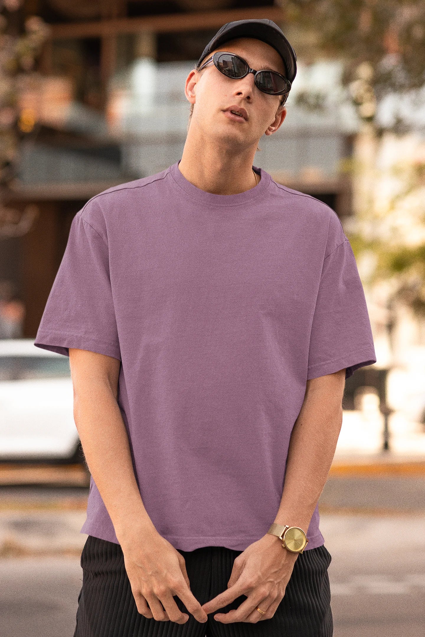 Front view of man wearing Dirty Purple coloured Oversize T-shirt featuring Taylor Swift 1989 design on its back, Taylor's Version, and Eras Tour Merch