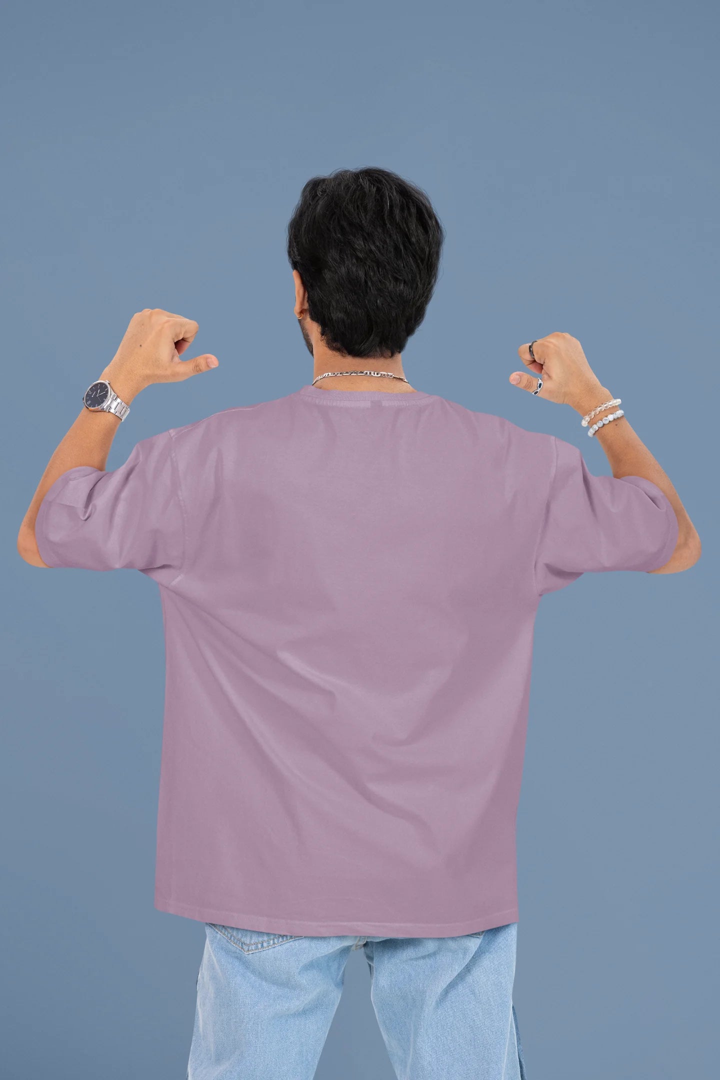 Back view of a male model wearing a dirty purple oversized t-shirt with the text "Oh Snap!" and a broken heart symbol underneath.