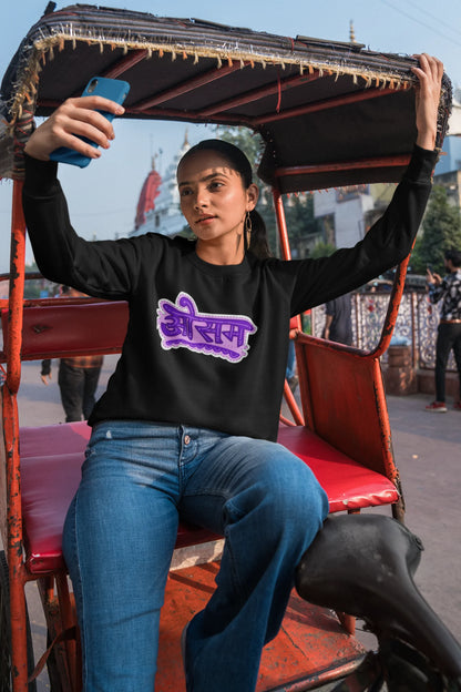 2nd front view of a female model wearing a black colored oversized graphic t-shirt featuring the word "awesome" in a Hindi script.