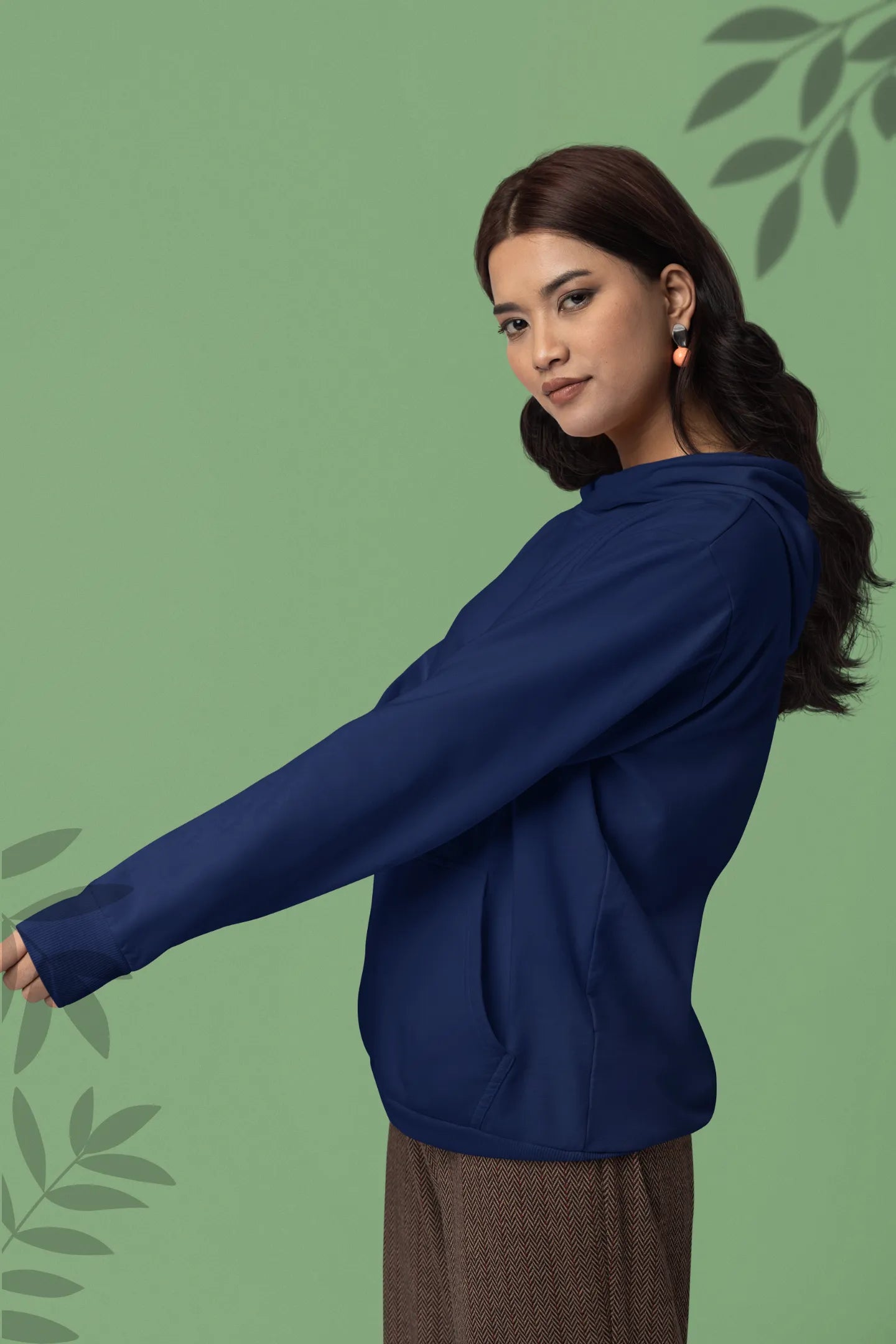 Second front view of a female model wearing a navy blue hoodie with a design of a wildcat sitting on ocean waves.