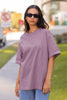 Front view of a woman wearing Dirty Purple coloured Oversize T-shirt featuring Taylor Swift 1989 design on its back, Taylor's Version, and Eras Tour Merch