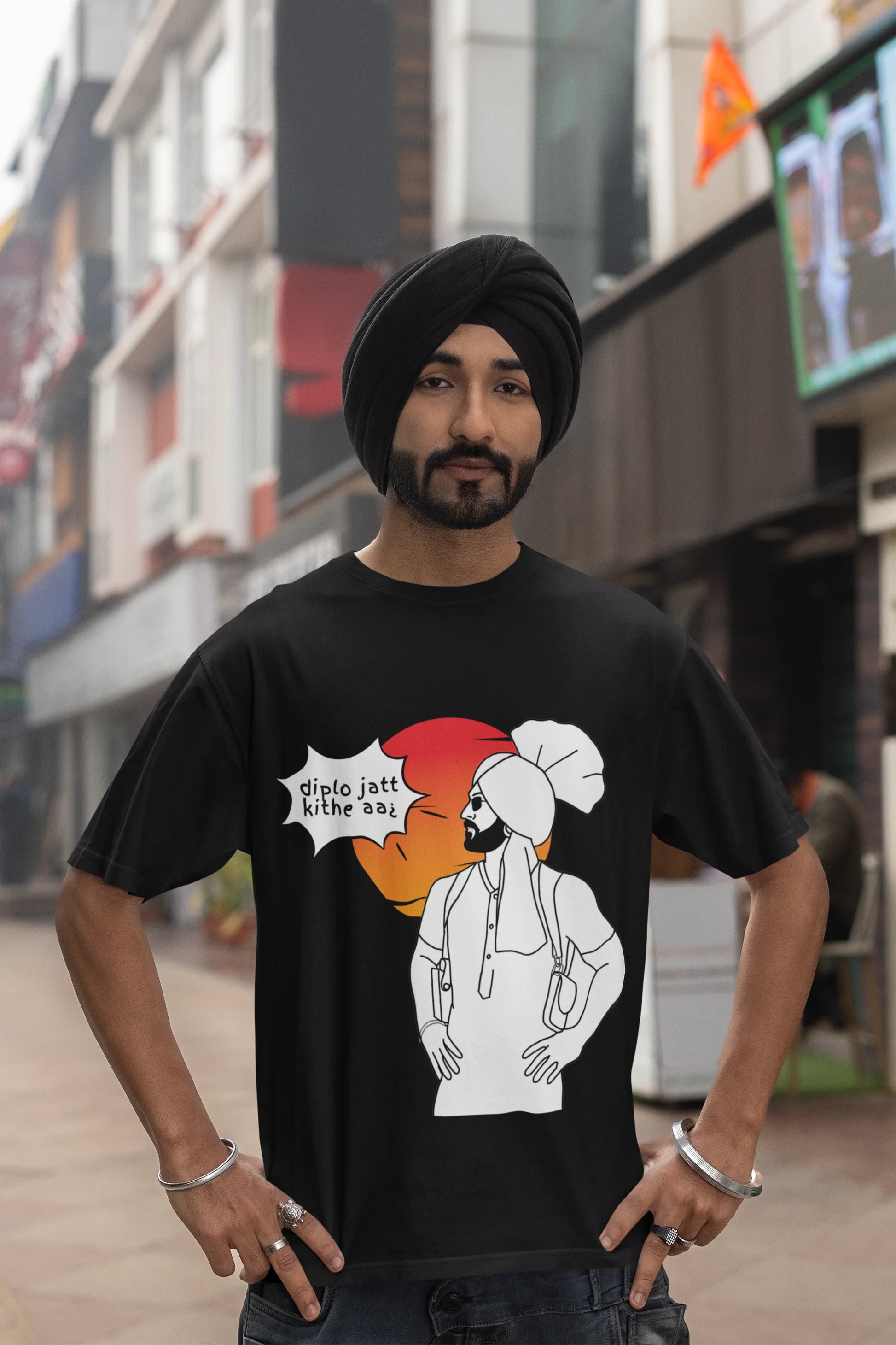 Third image of a male model wearing a black oversized tshirt with a A portrait of Diljit Dosanjh wearing a stylish outfit, with the text "Diplo Jatt Kithe Aai" prominently displayed in the background. The design captures the artist's charisma and the energy of the hit song, making it a must-have for fans of Diljit Dosanjh and Diplo alike. 