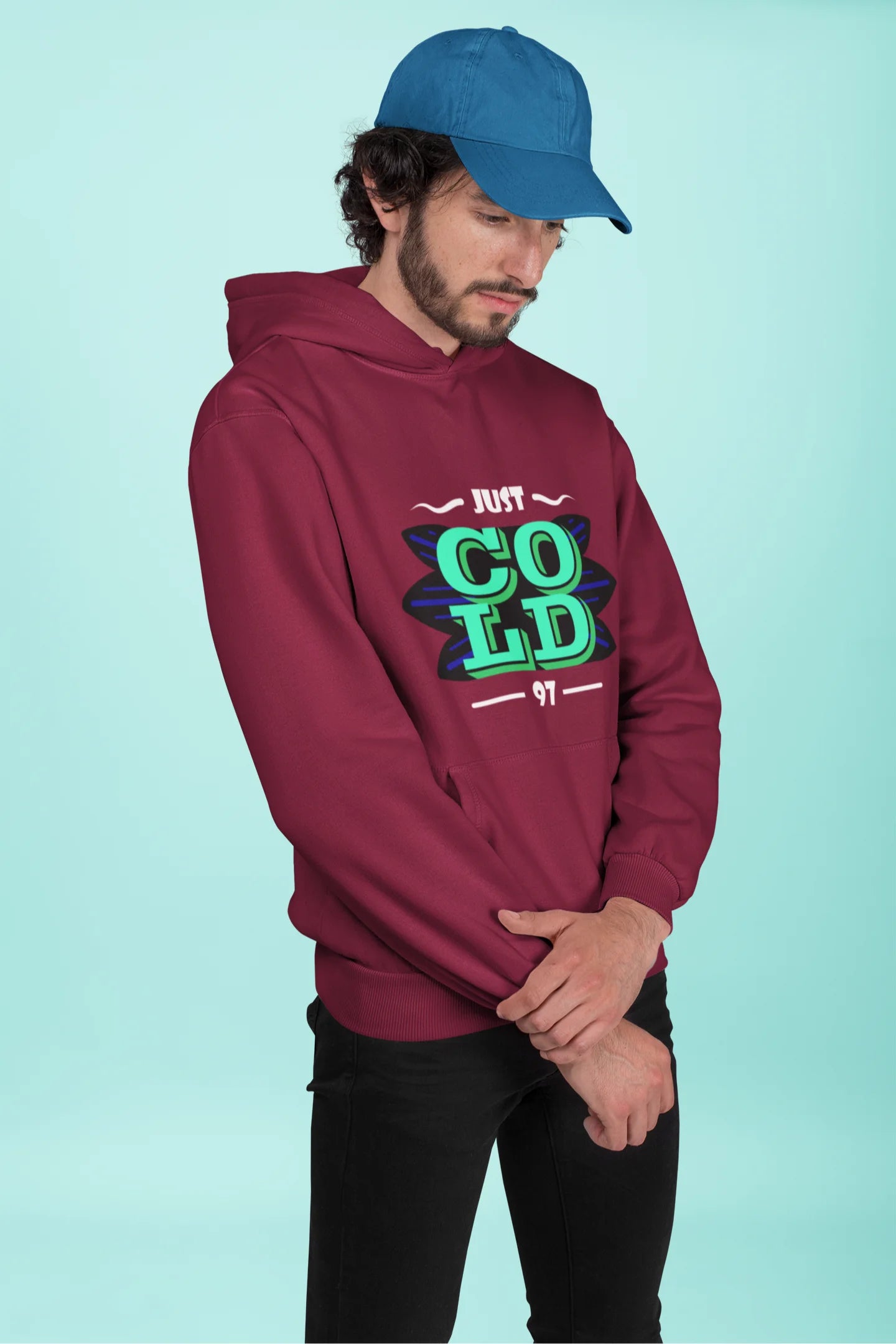 First front view of a male model wearing an maroon sweatshirt with the text "Just Cold" printed on it.