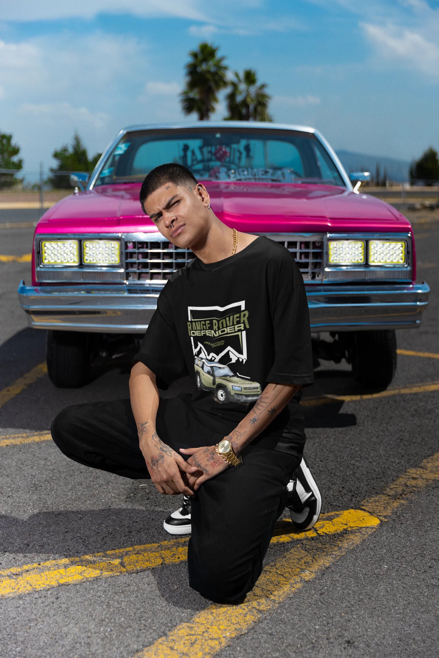 2nd front view of a male model  wearing a black oversized t-shirt featuring a design of a Range Rover.