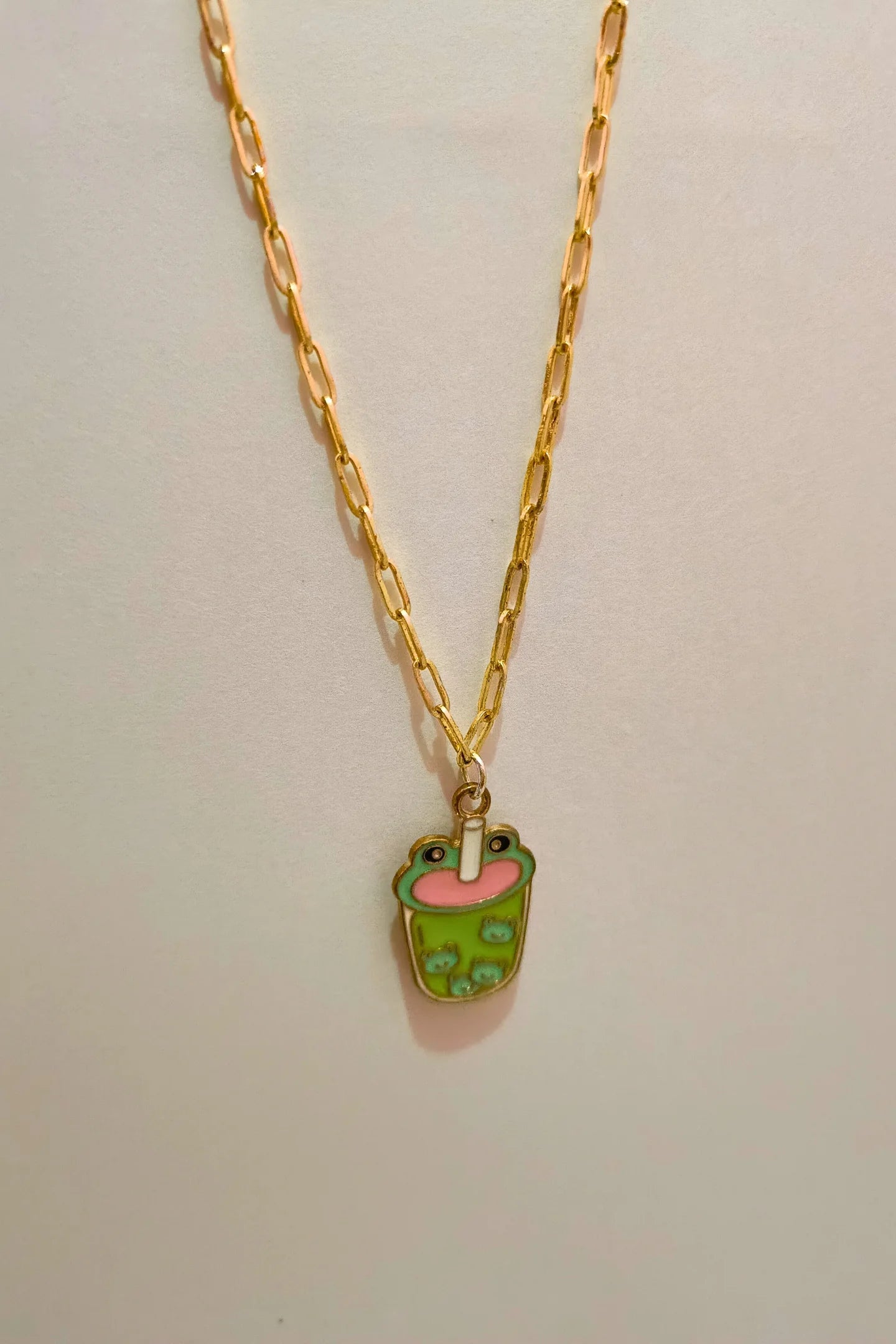 4th view of a gold chain necklace featuring a small pendant of a frog themed boba cup.
