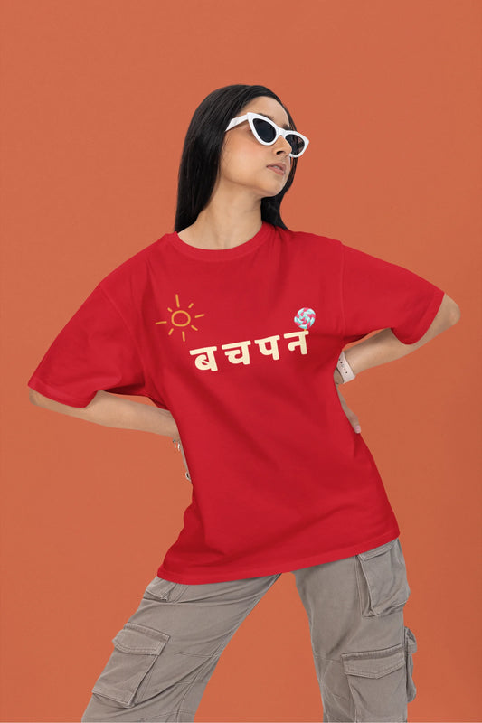 First front view of a female model wearing a red oversized t-shirt with a design representing "Bachpan" (childhood) and the concept of "Khatta Mitha" (sweet and sour).