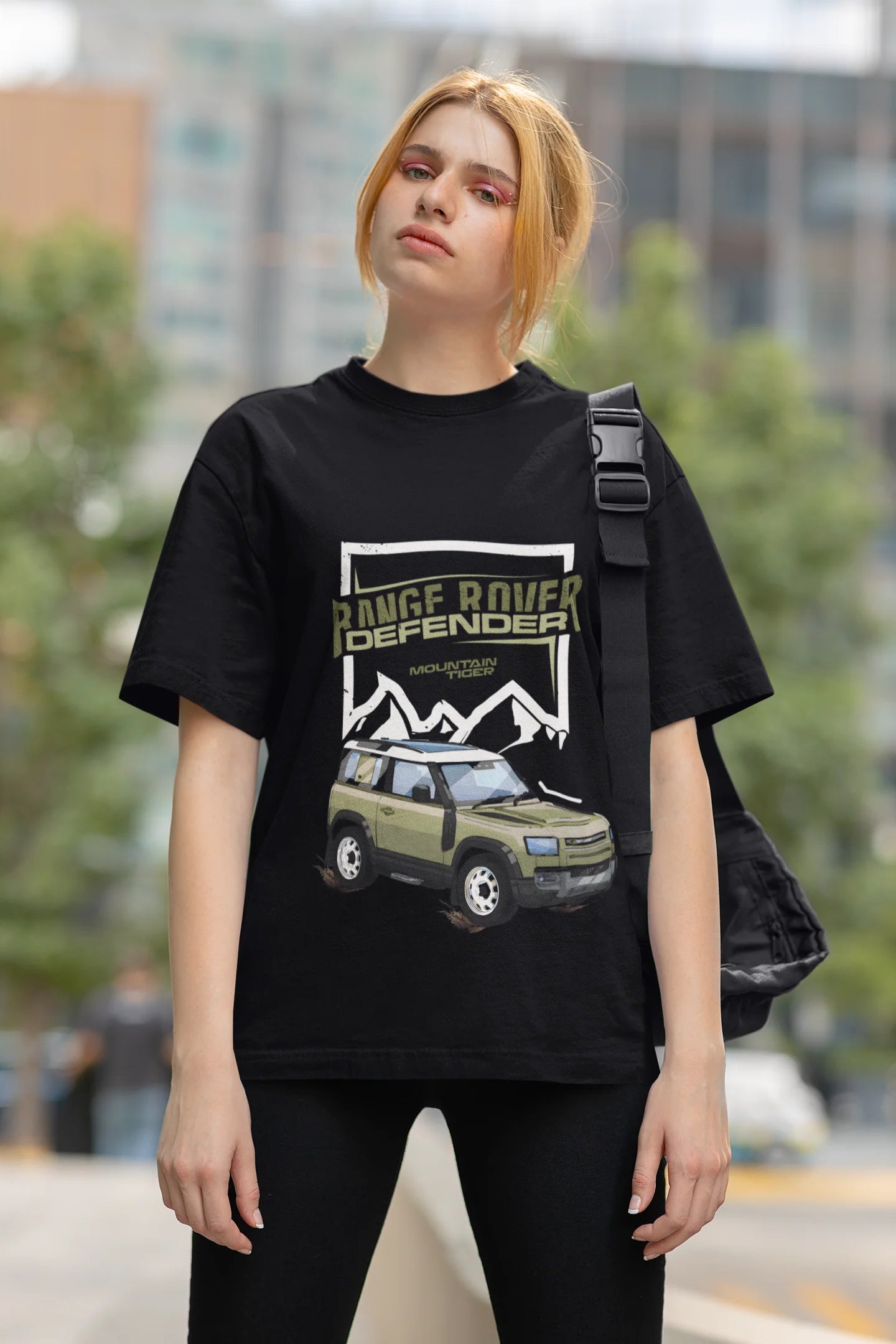 First front view of a female model  wearing a black oversized t-shirt featuring a design of a Range Rover.