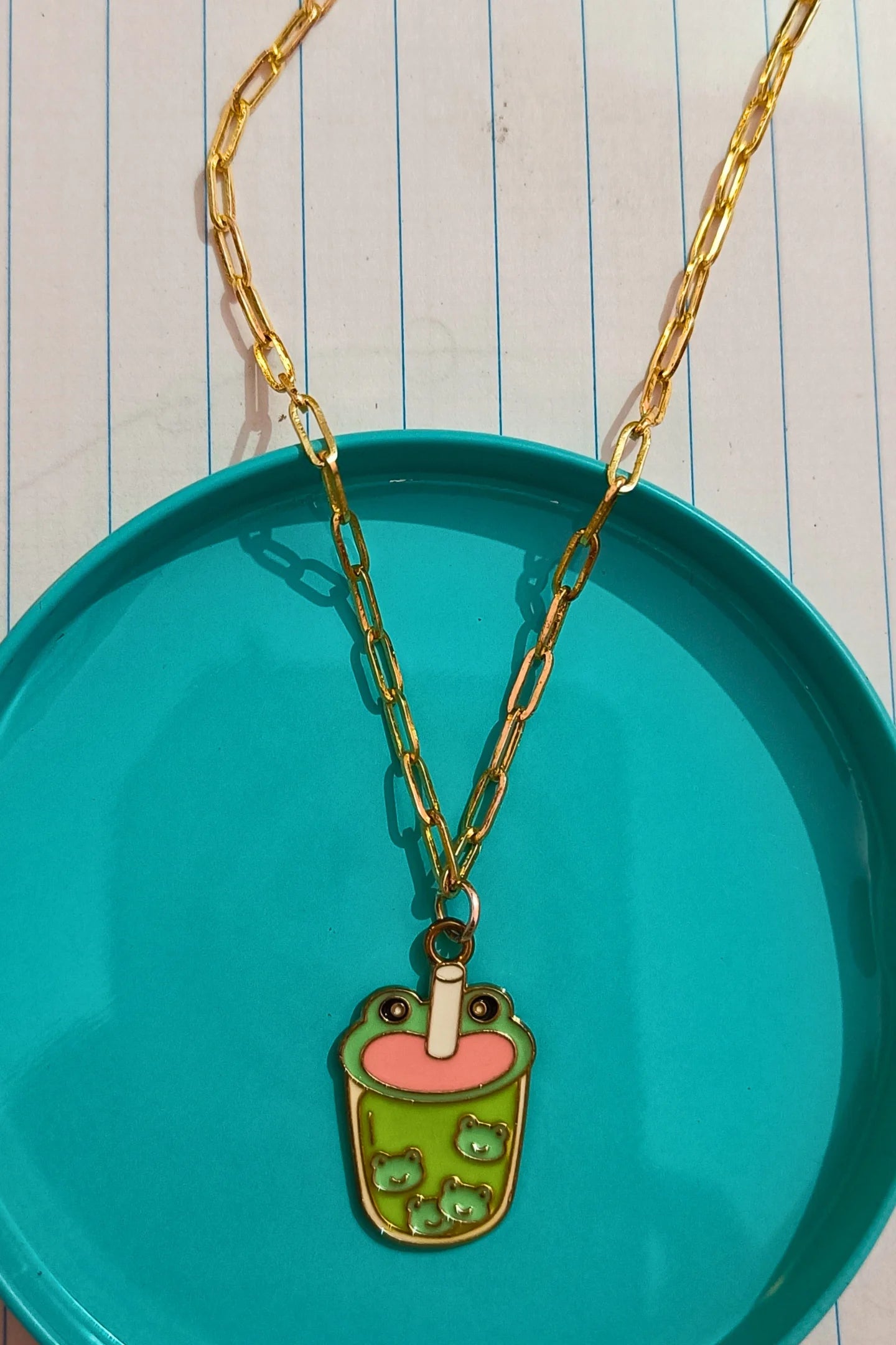 2nd view of a gold chain necklace featuring a small pendant of a frog themed boba cup.