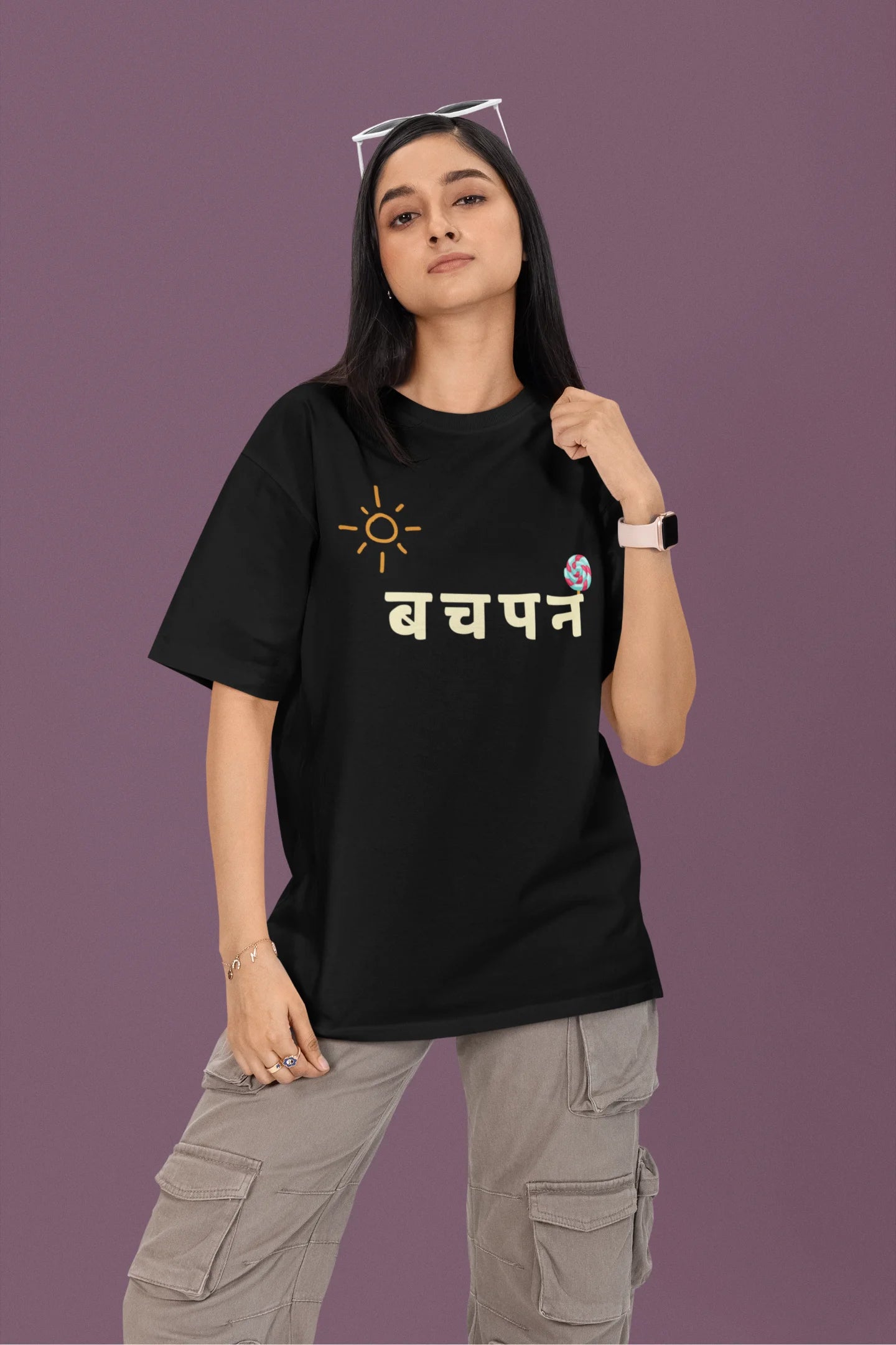 2nd front view of a female model wearing a black oversized t-shirt with a design representing "Bachpan" (childhood) and the concept of "Khatta Mitha" (sweet and sour).