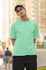 Front view of male model wearing a mint green oversized F.R.I.E.N.D.S. t-shirt featuring a design inspired by Joey Tribbiani's funny quotes and signature charm.