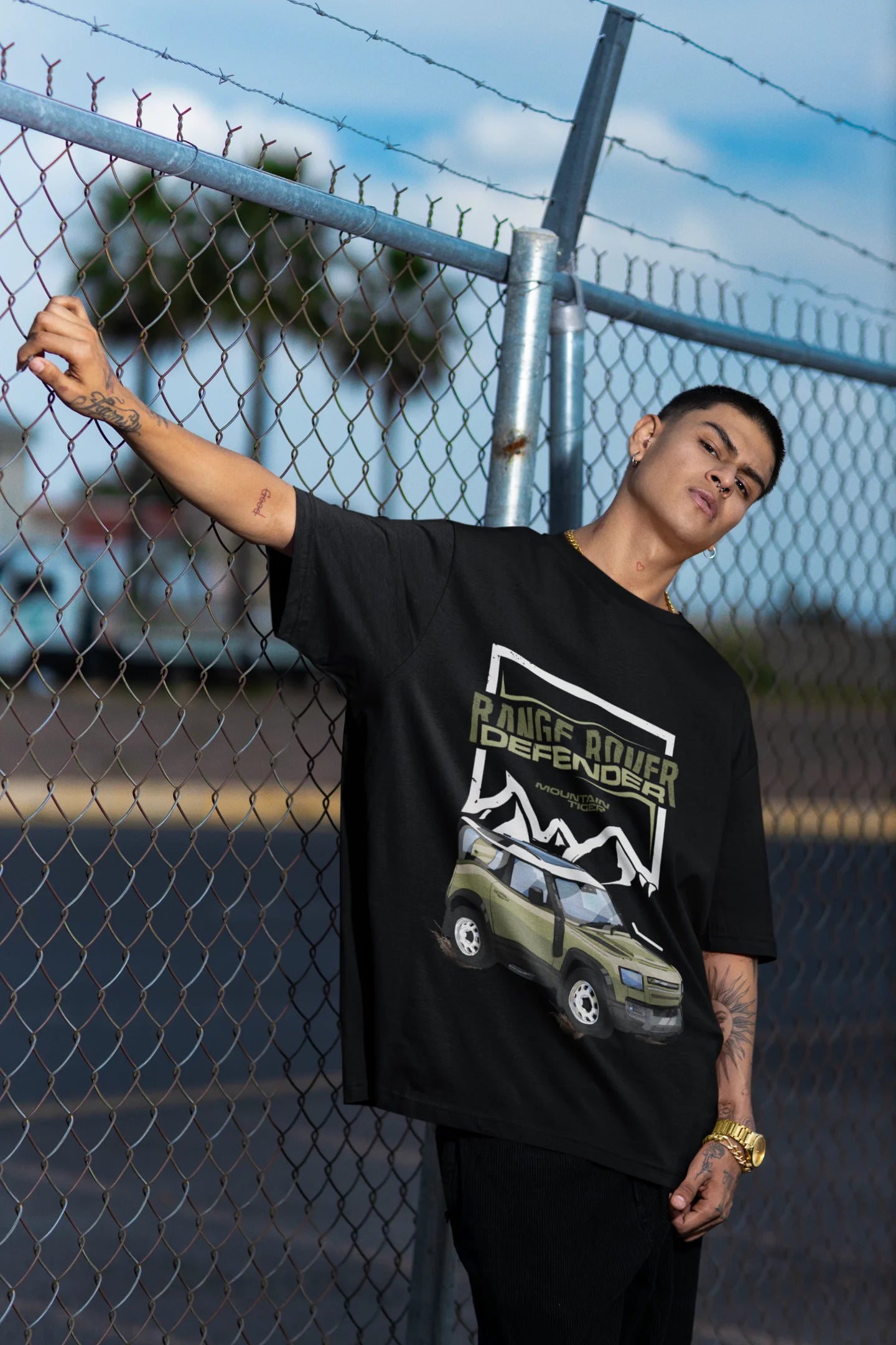 First front view of a male model  wearing a black oversized t-shirt featuring a design of a Range Rover.