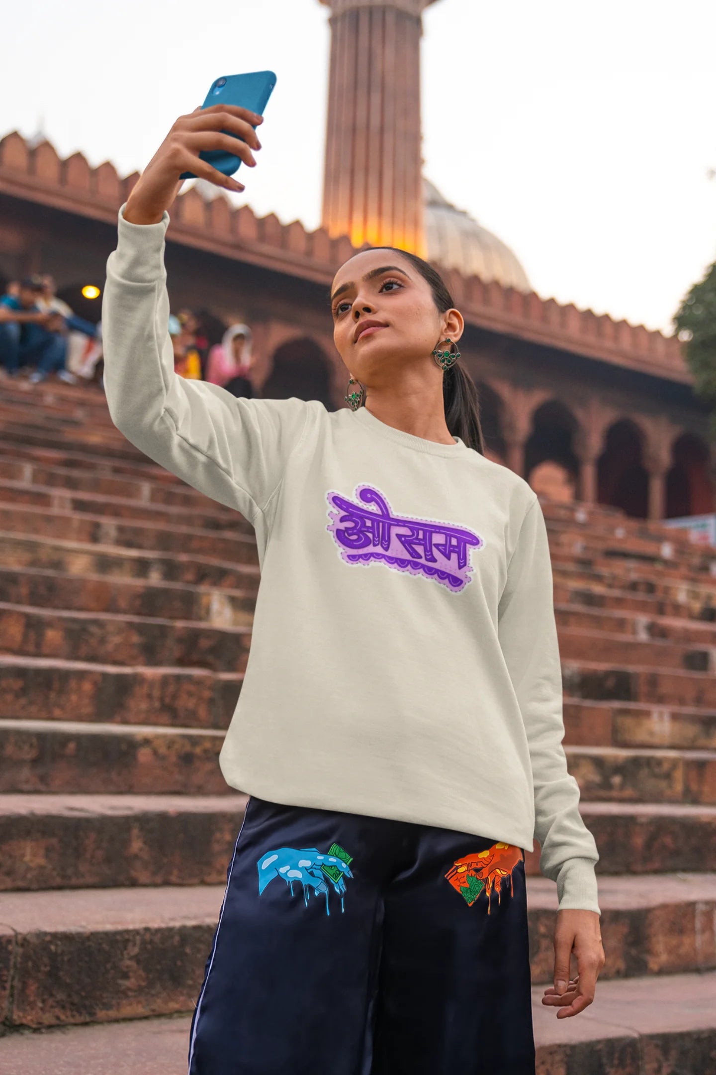 4th front view of a female model wearing a cream colored oversized graphic t-shirt featuring the word "awesome" in a Hindi script.