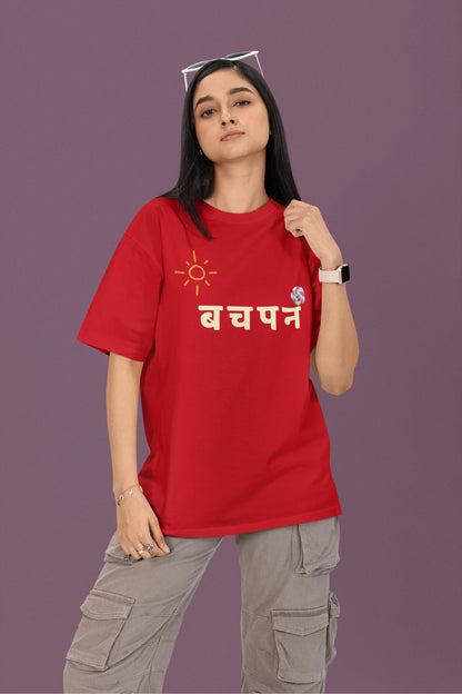 2nd front view of a female model wearing a red oversized t-shirt with a design representing "Bachpan" (childhood) and the concept of "Khatta Mitha" (sweet and sour).