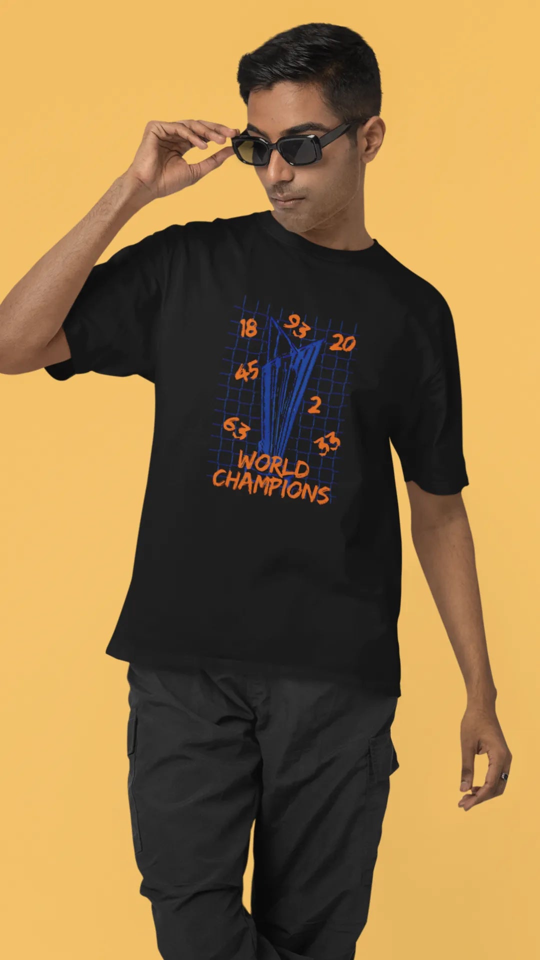 First front image of male model wearing a black oversized t-shirt featuring the World Cup 2024 trophy with the text "World Champions" underneath. Ideal for Indian cricket fans celebrating their team's victory.