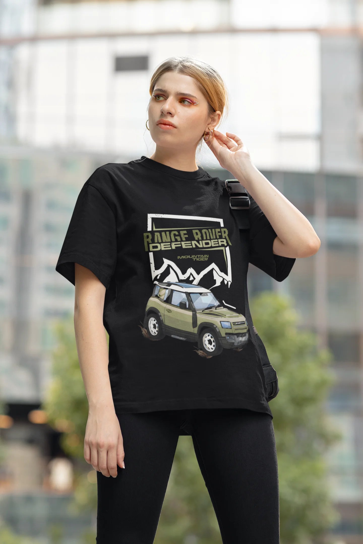 2nd front view of a female model  wearing a black oversized t-shirt featuring a design of a Range Rover.