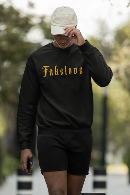 First front view of a male model wearing a black sweatshirt with a brutalist design featuring a fallen angel statue and the phrase "Fake Love".