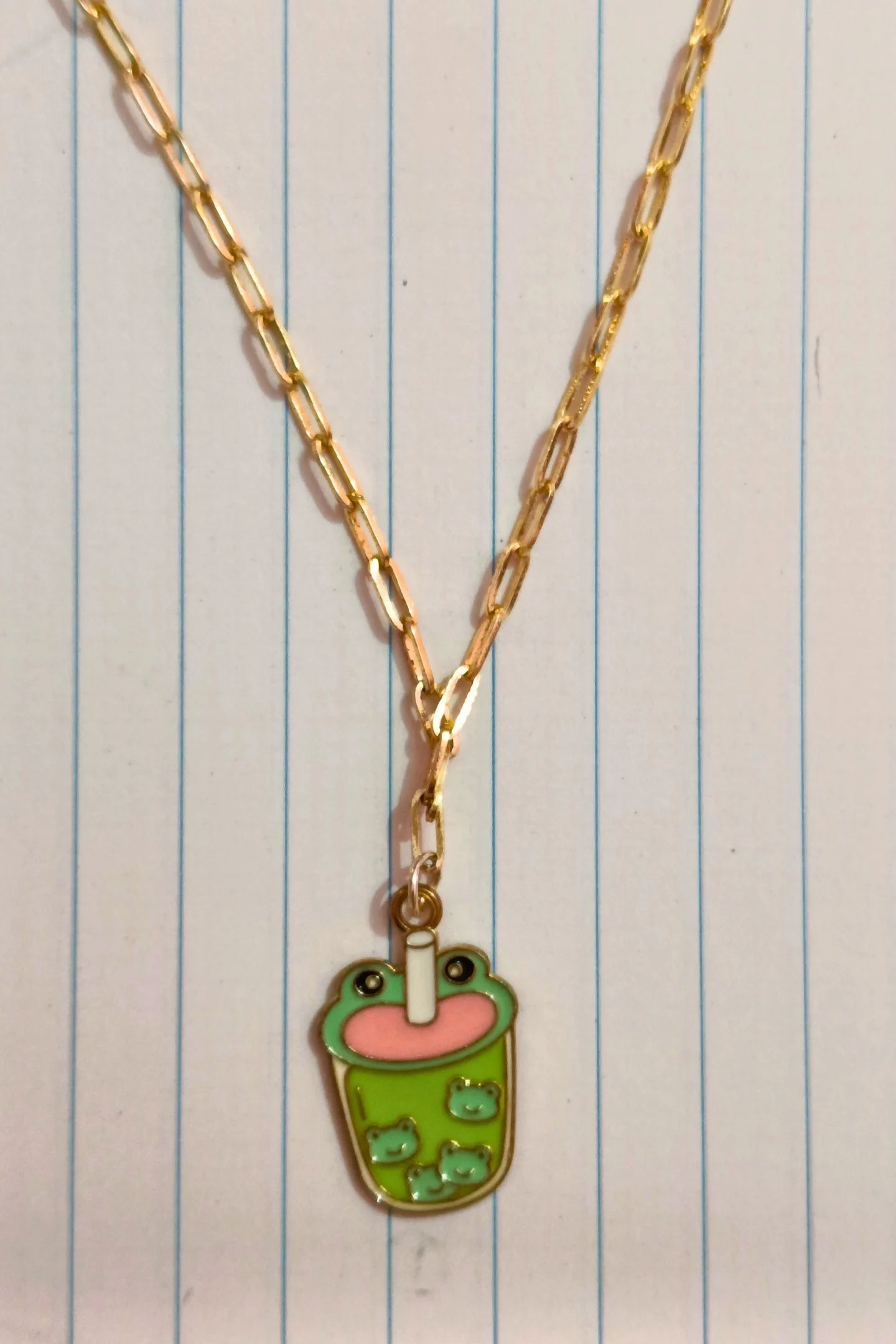 First view of a gold chain necklace featuring a small pendant of a frog themed boba cup.