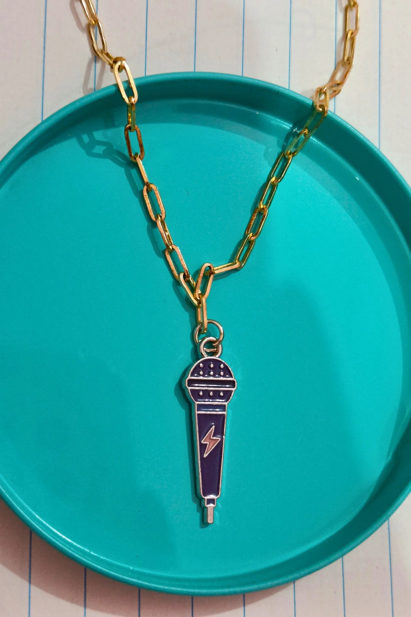 First view of a gold chain necklace with a small pendant shaped like a K-Pop microphone.