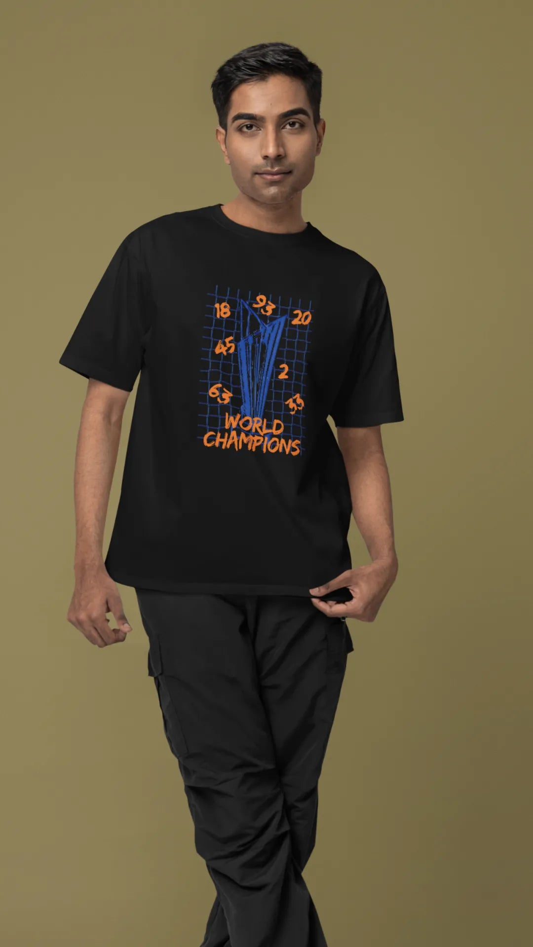 Second front image of male model wearing a black oversized t-shirt featuring the World Cup 2024 trophy with the text "World Champions" underneath. Ideal for Indian cricket fans celebrating their team's victory.