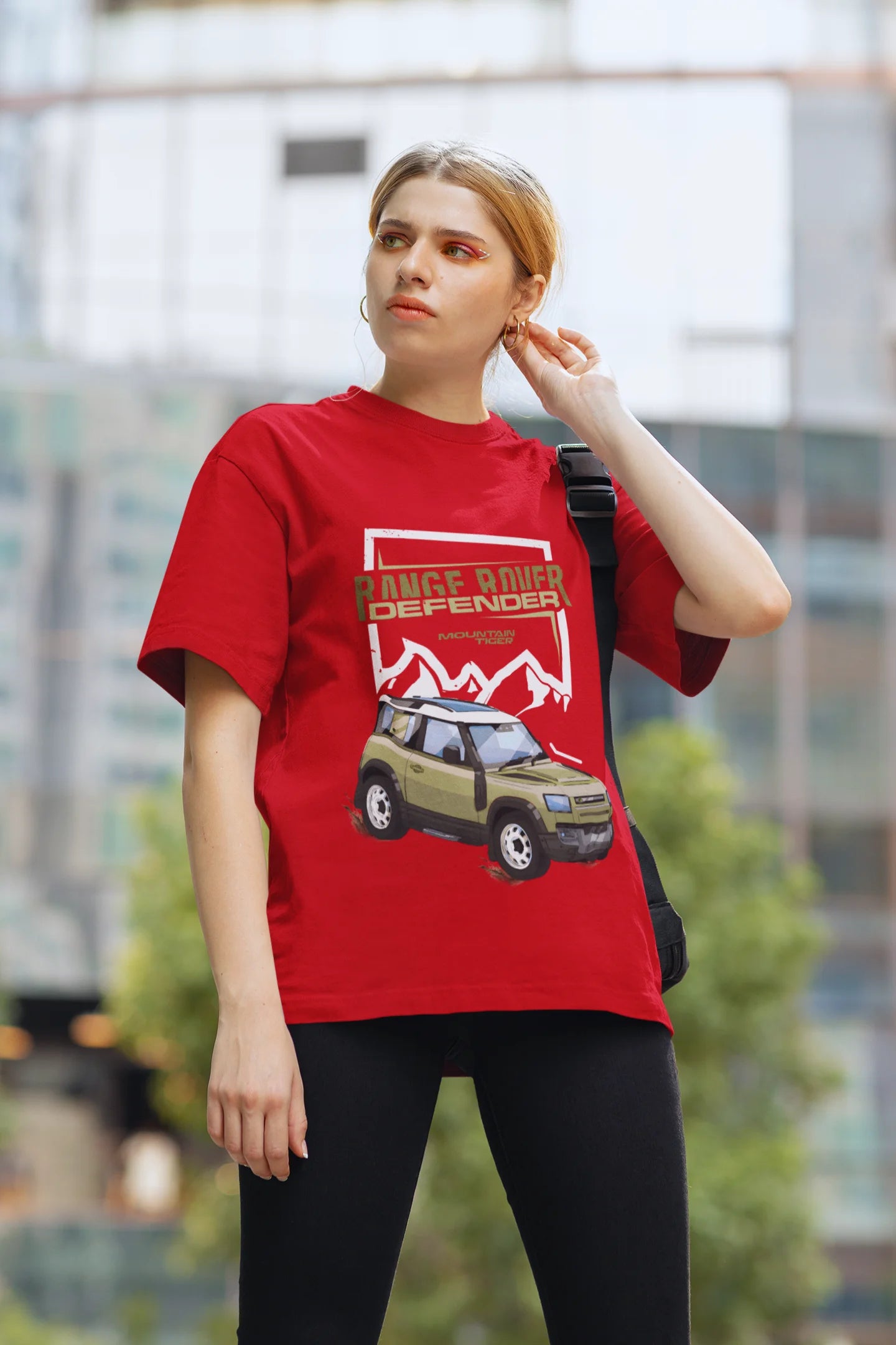 2nd front view of a female model wearing a red oversized t-shirt featuring a design of a Range Rover.