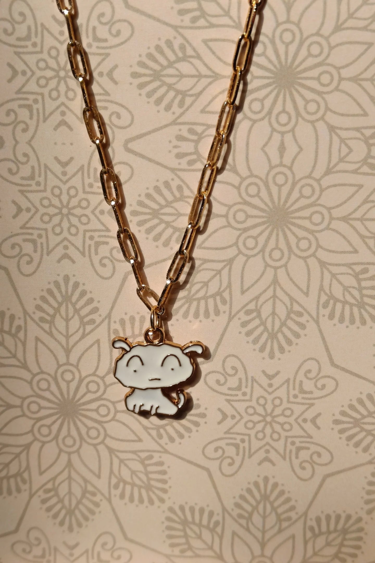 4th view of a gold chain necklace with a small pendant depicting Shero from the anime Shin Chan.