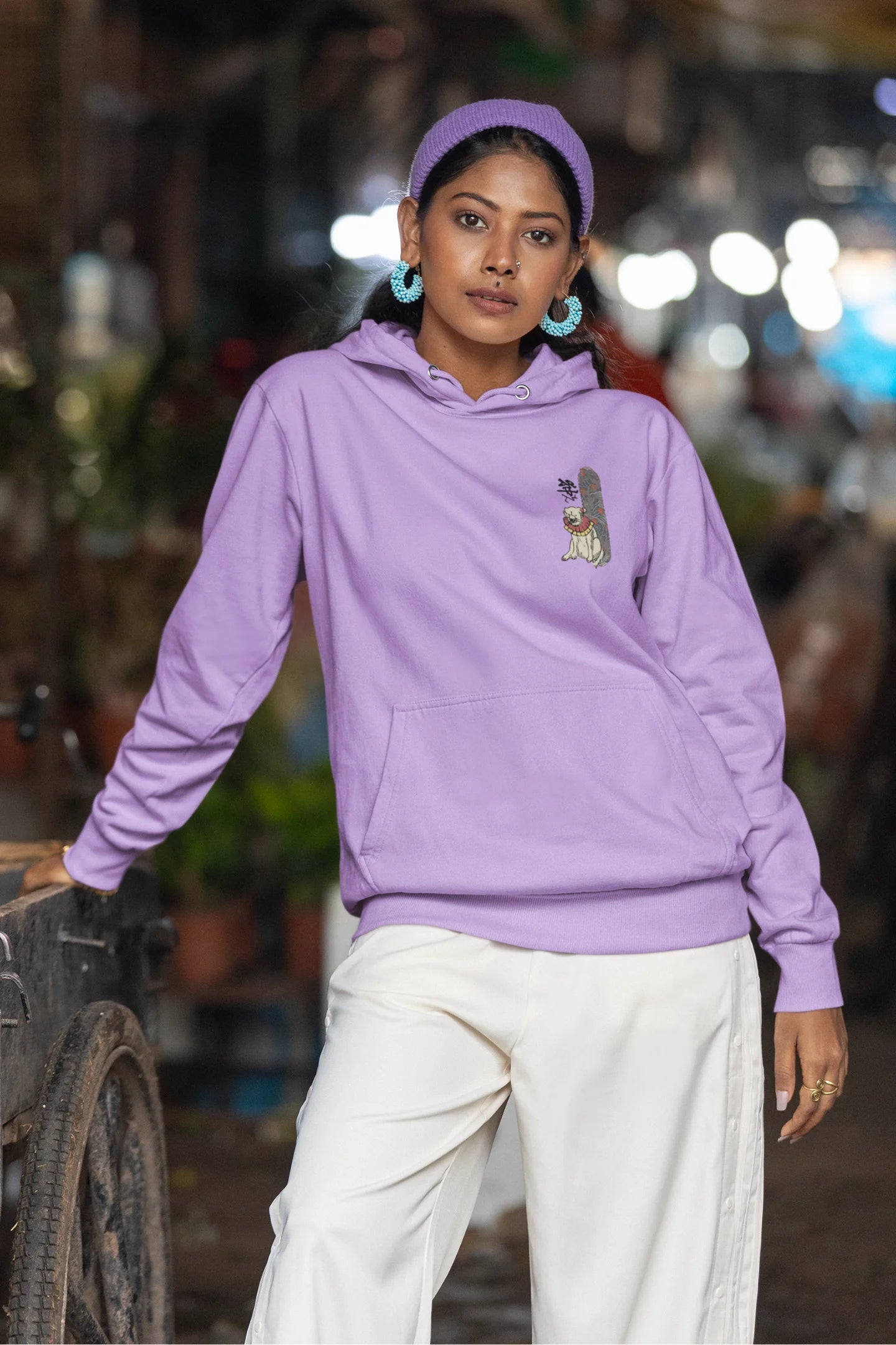 Third front view of a female model wearing a lavender hoodie with a design of a mythical Japanese dog.