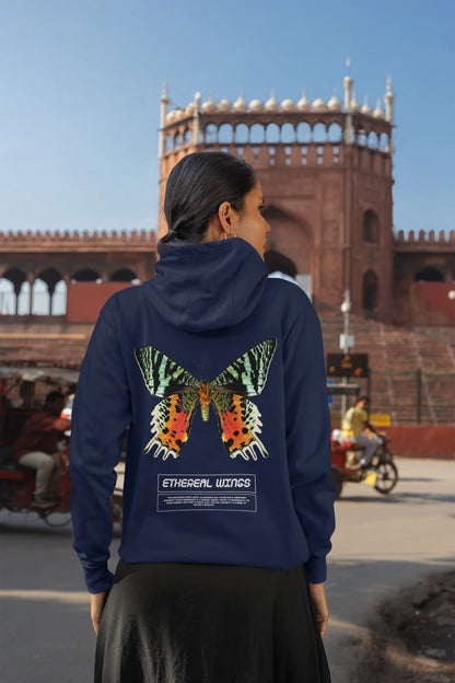 Back view of a female model wearing a navy blue hoodie with a glowing butterfly design, symbolizing the ethereal beauty of nature.