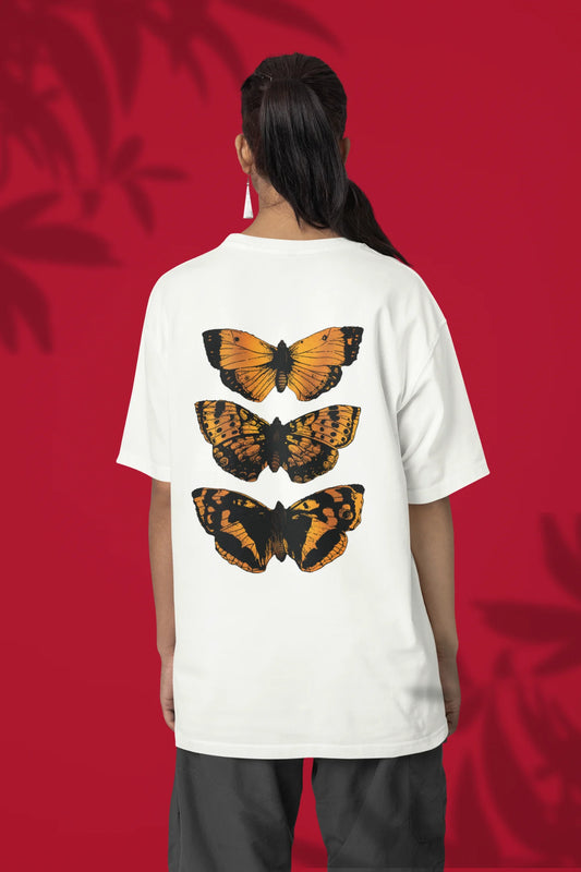 Back view of a female model wearing a off-white oversized tee with a design featuring three different types of butterflies, symbolizing the beauty and diversity of nature.