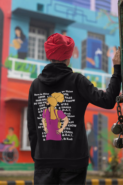 Back view of a female model wearing a black hoodie with a portrait of Diljit Dosanjh and lyrics from the song "Ikk Kudi."