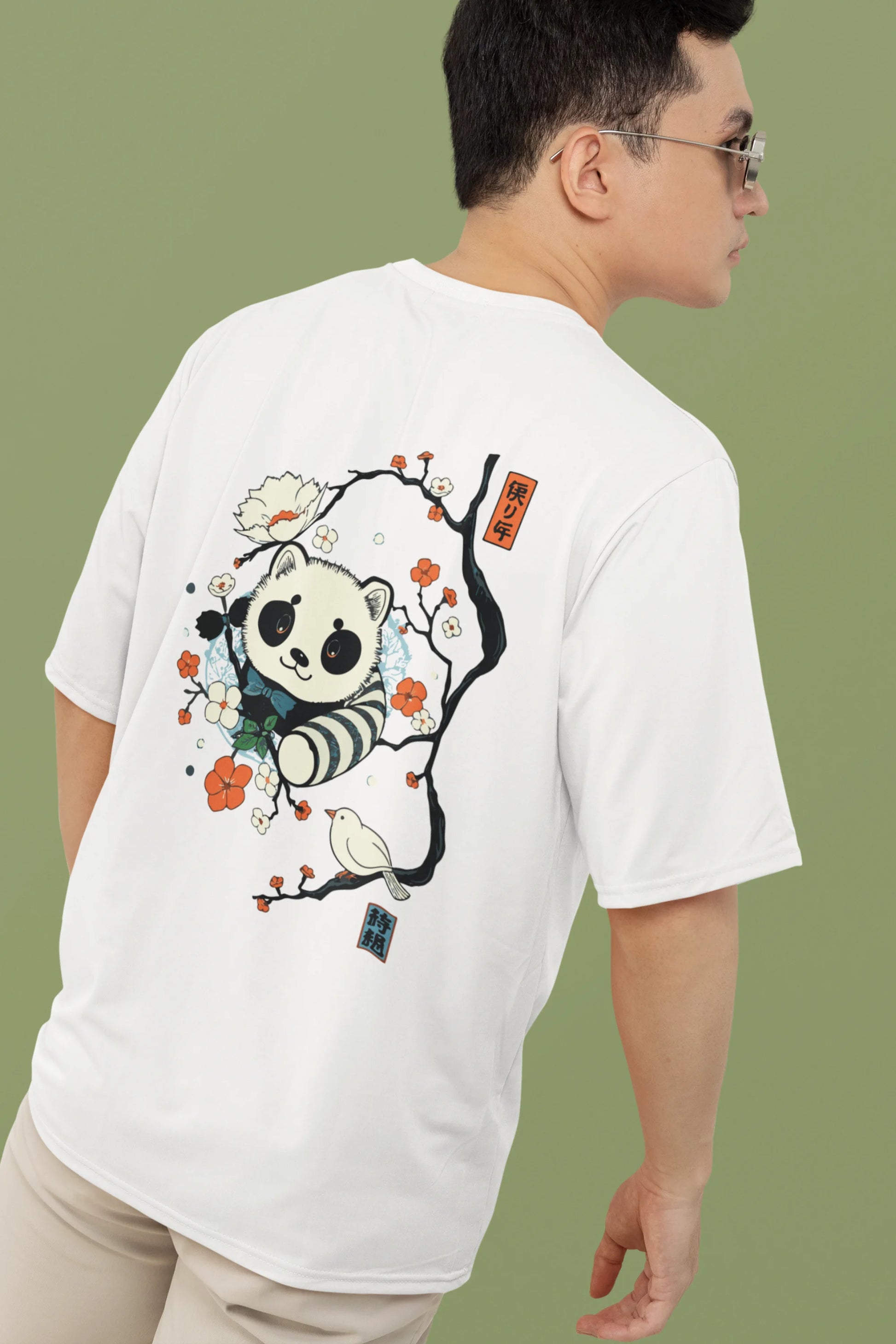 Another back view of a male model wearing a off white oversized tee with a panda fox surrounded by bamboo.