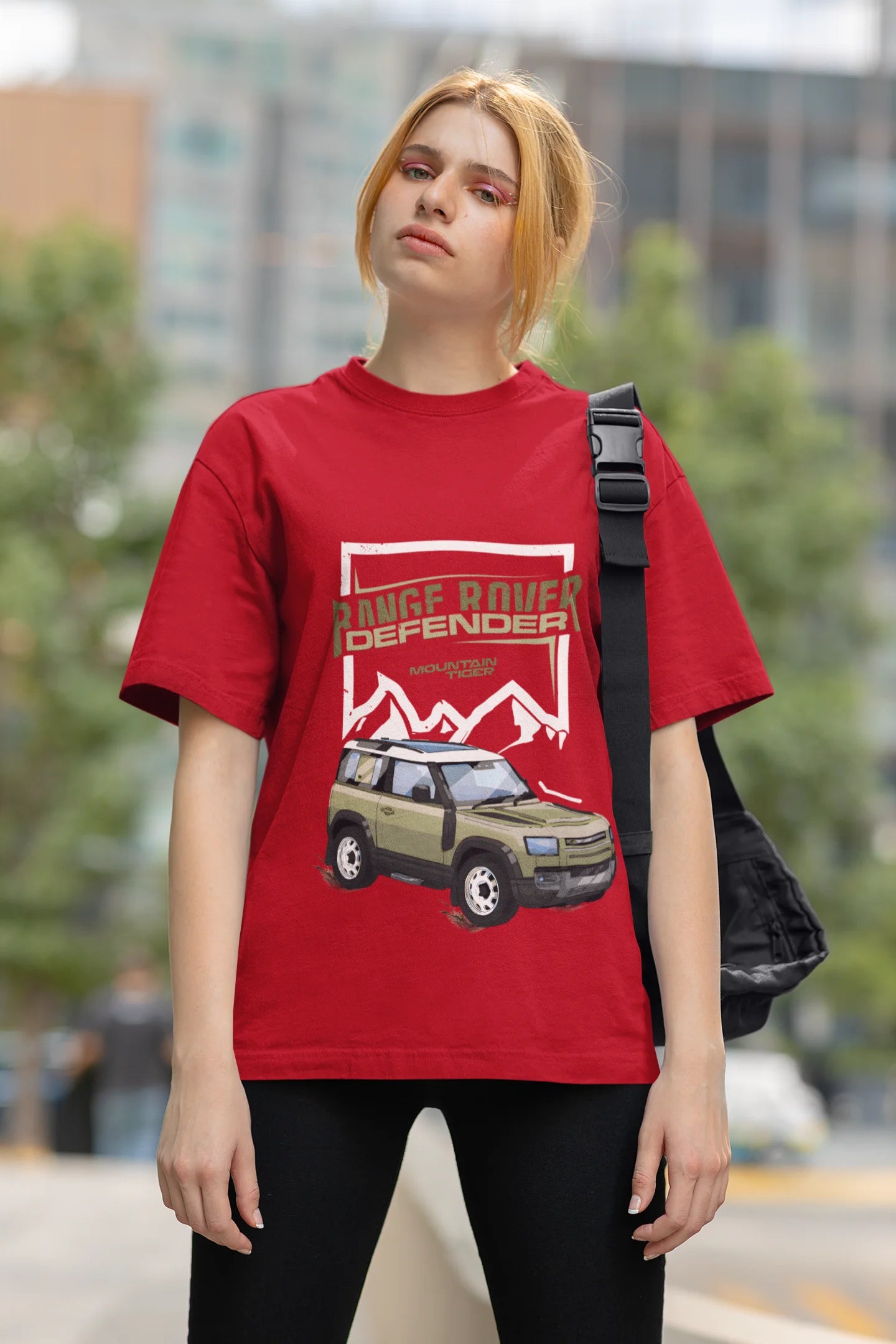 First front view of a female model wearing a red oversized t-shirt featuring a design of a Range Rover.