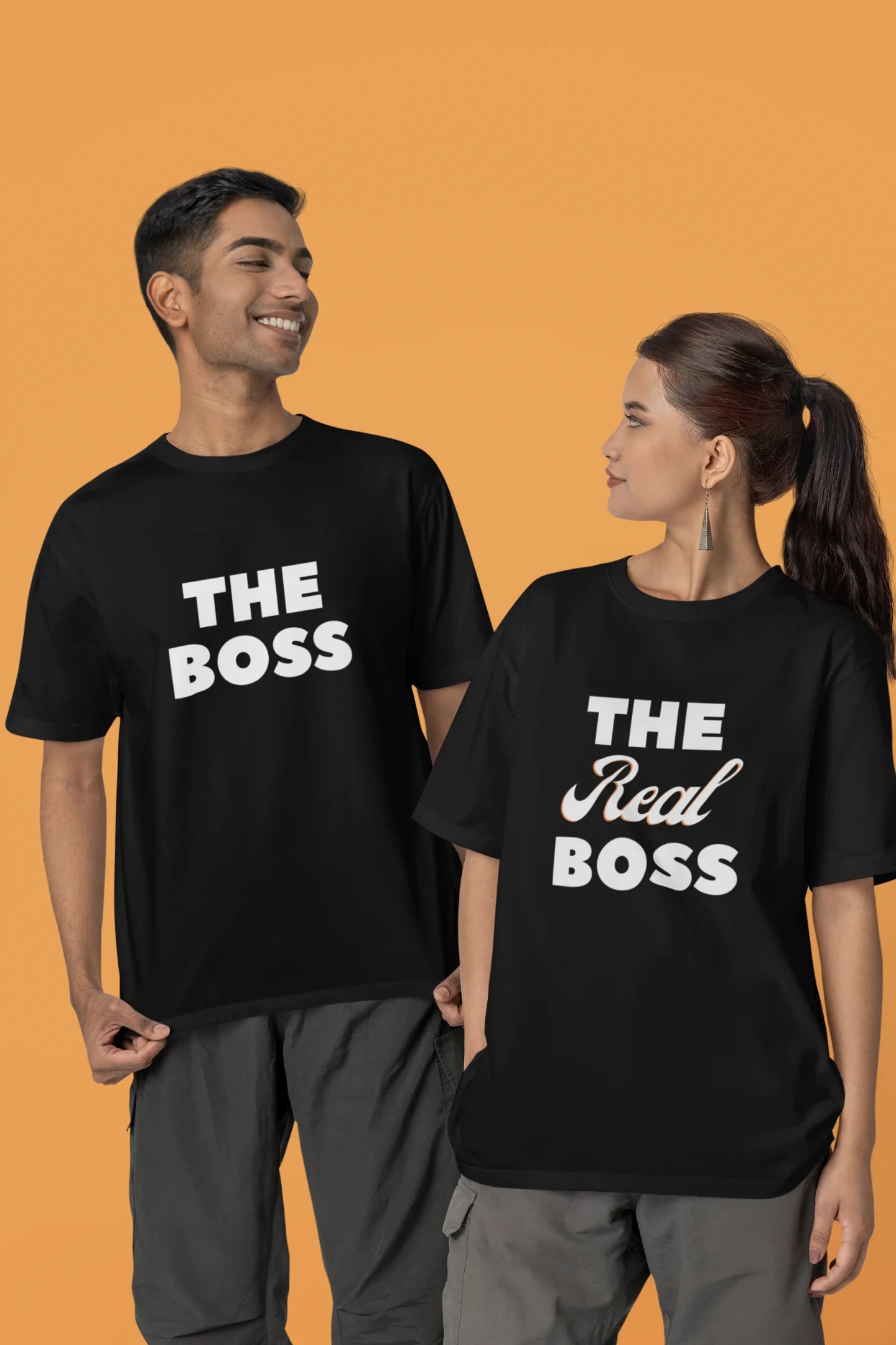 Second image of a smiling couple wearing matching black oversized tees, one with "The Boss" and the other with "The Real Boss" printed on them.