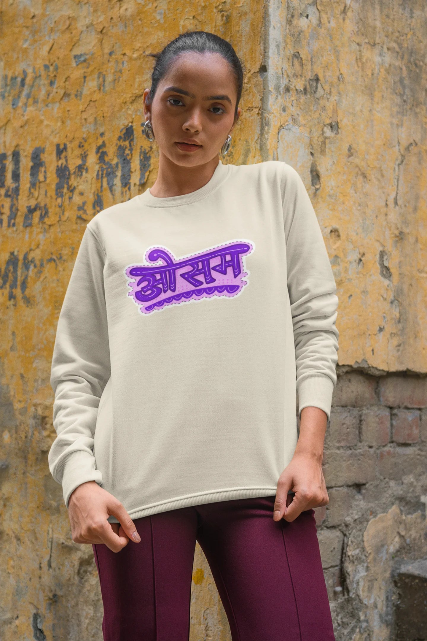 6th front view of a female model wearing a cream colored oversized graphic t-shirt featuring the word "awesome" in a Hindi script.