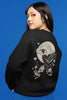 Back view of a female model wearing a black sweatshirt with a heron taking off under the moonlight.