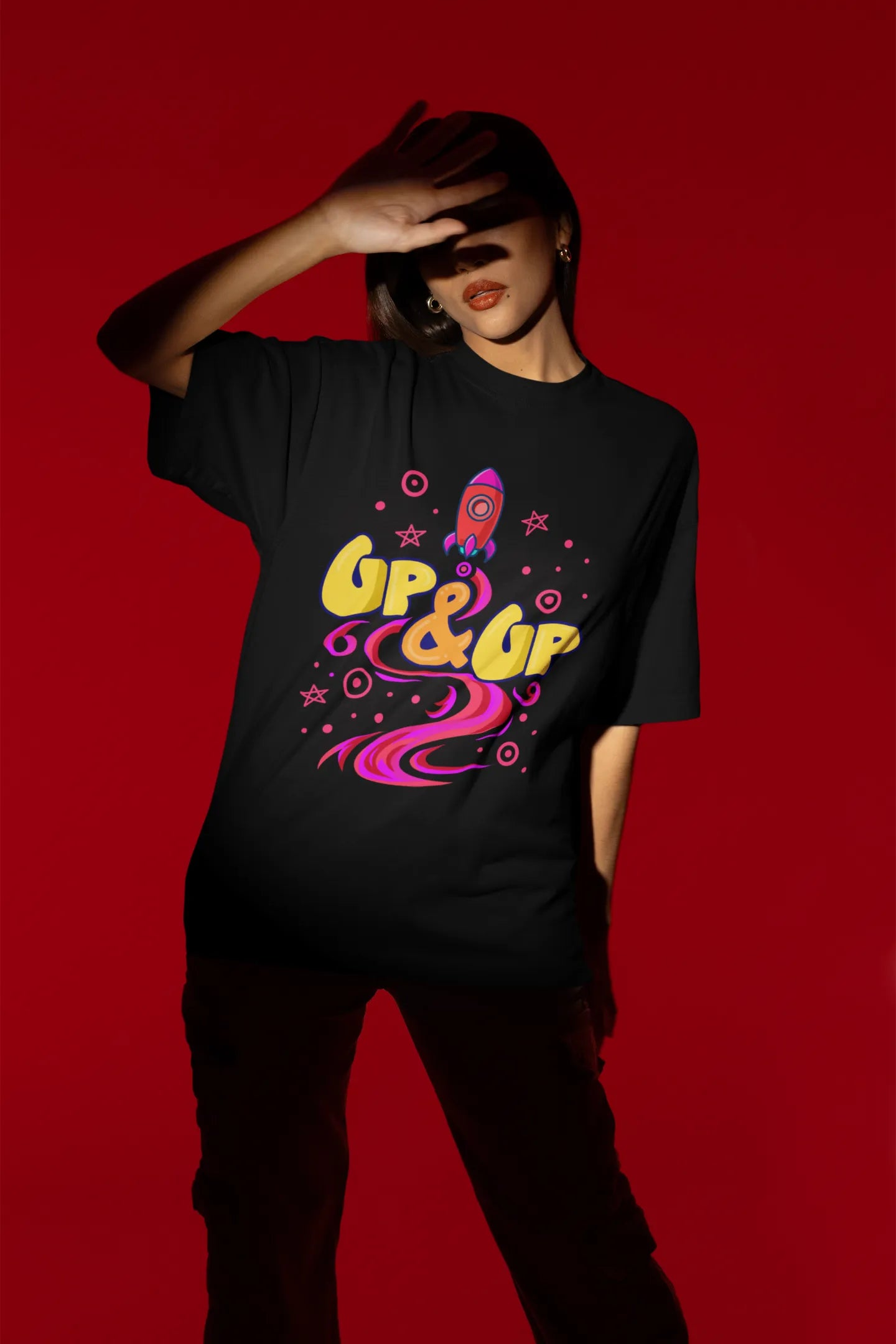 Second front view of a female model wearing an black oversized t-shirt with a rocket ship design and the text "Up & Up".