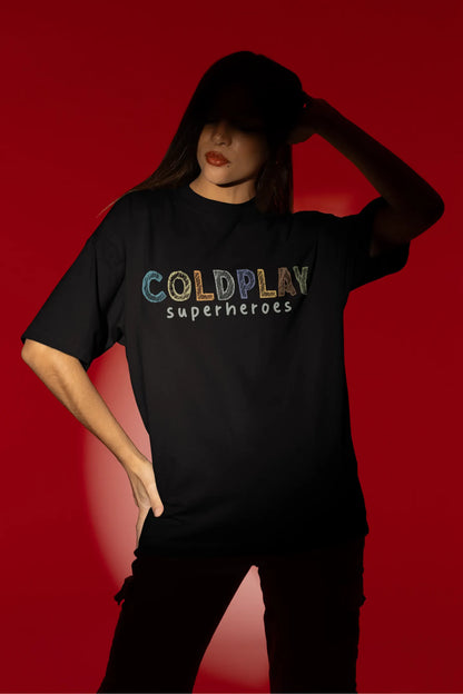 Fourth view of a female model wearing an black oversized t-shirt with a design inspired by the "Something Just Like This" music video, featuring the word "Superheroes".