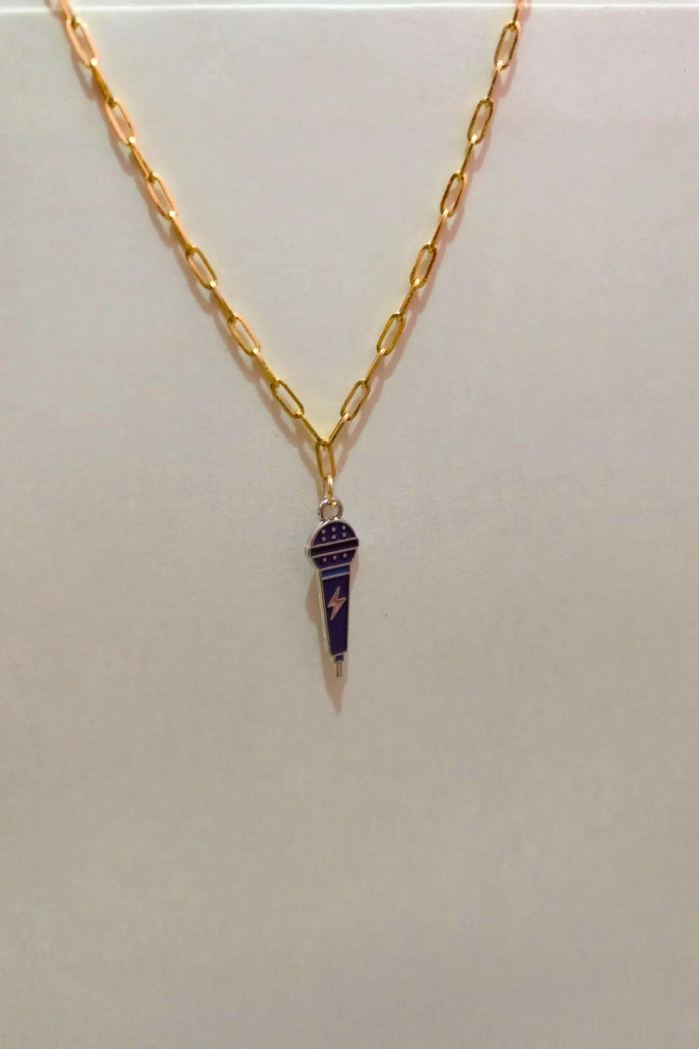 4th view of a gold chain necklace with a small pendant shaped like a K-Pop microphone.