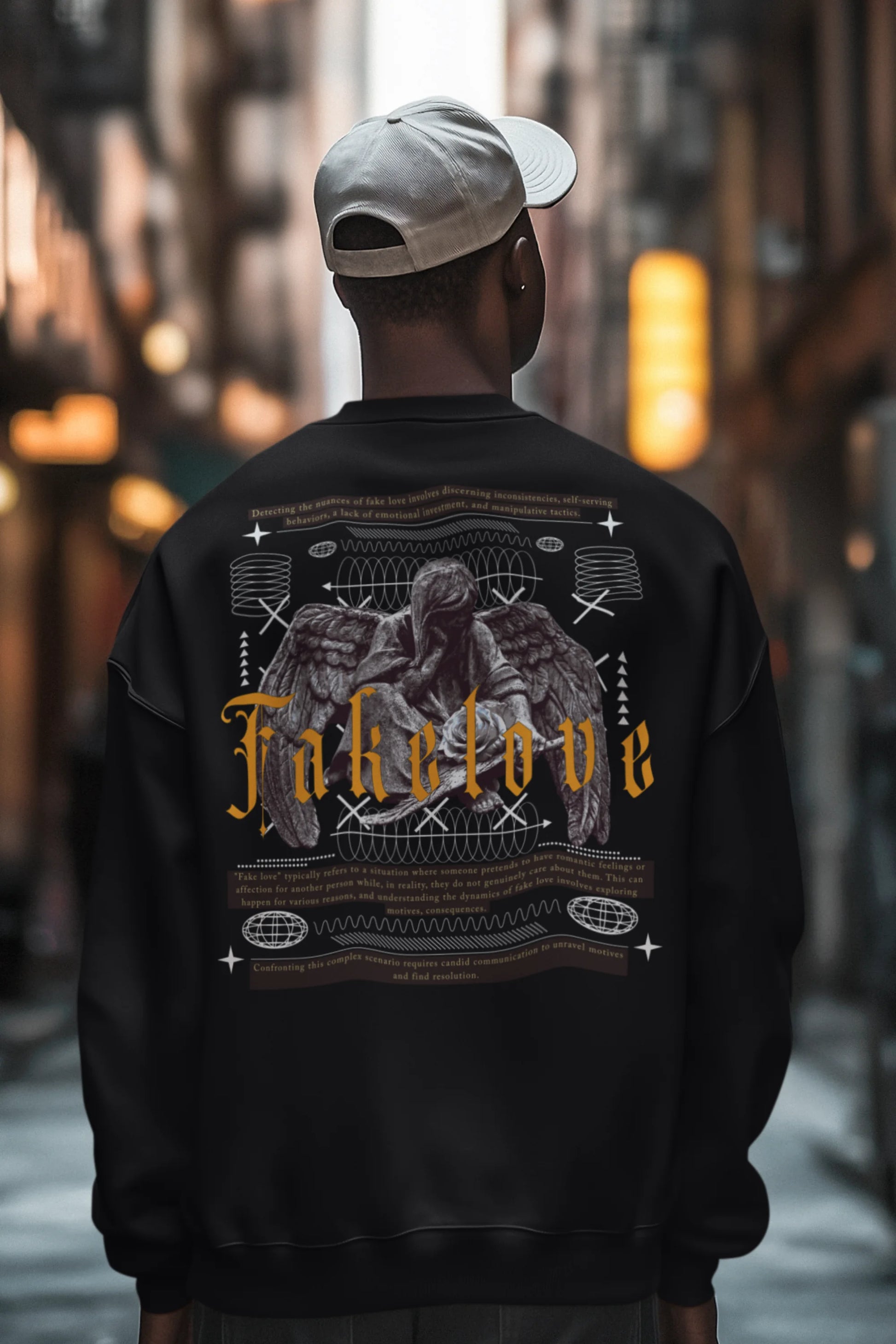 Second back view of a male model wearing a black sweatshirt with a brutalist design featuring a fallen angel statue and the phrase "Fake Love".